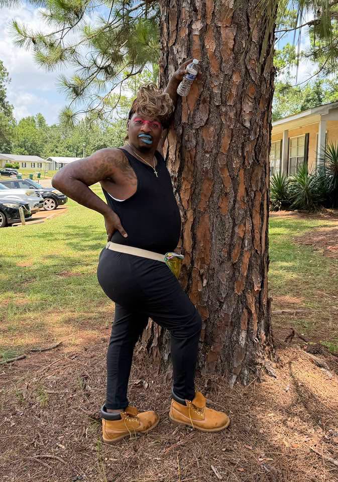 Laquanda posing beside a pine tree